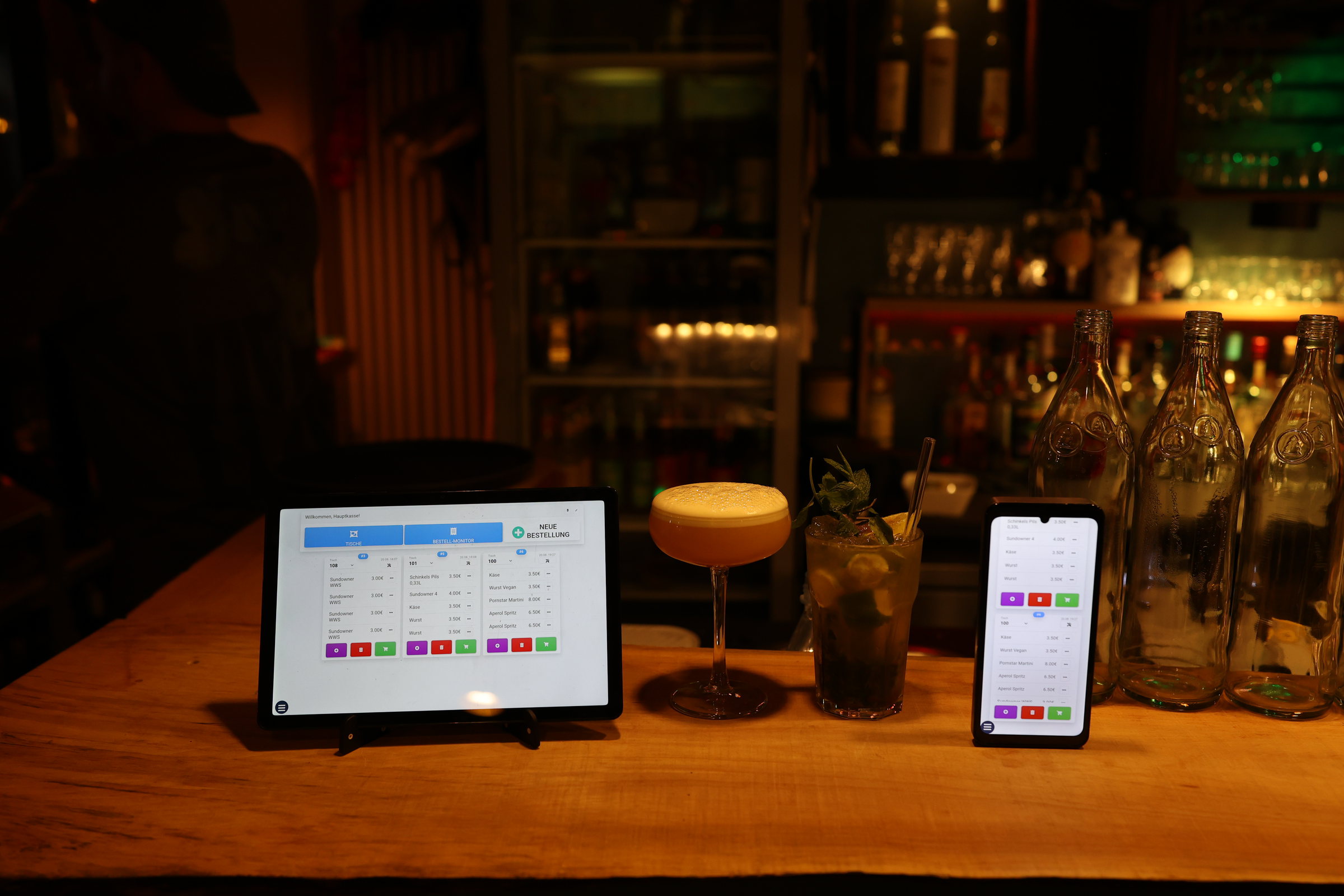 Payline Kasse und Orderman neben Drinks auf einer Bar